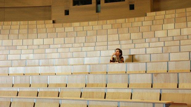 Eine Studentin allein im Hörsaal - Examensvorbereitung ist eine einsame Zeit